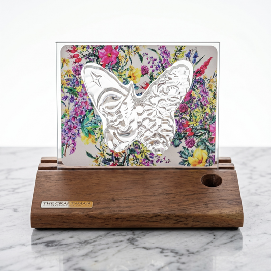 Decorative crystal butterfly on a floral background with a wooden base, branded 'The Craftsman'.