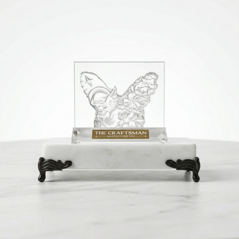 Butterfly-shaped crystal on a marble stand with 'The Craftsman' branding.