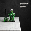 Green glass Man sculpture with a diamond on top standing along with fist pen stand placed on a black glass base 