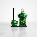Green glass man standing along with fist shaped pen stand on a black glass base kept on marble surface