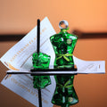 Green glass man standing along with a fist shaped pen stand on a black marble base.