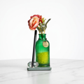Green glass vase filled with fragrance beads with flowers placed on a green marble with crystal pen stand