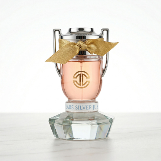 Rose essence trophy shaped perfume bottle with a gold ribbon bow doubles as a paperweight on a white background